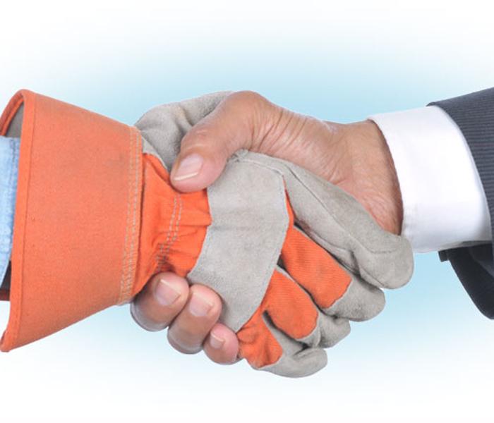 hand in work glove shaking hand in suit jacket